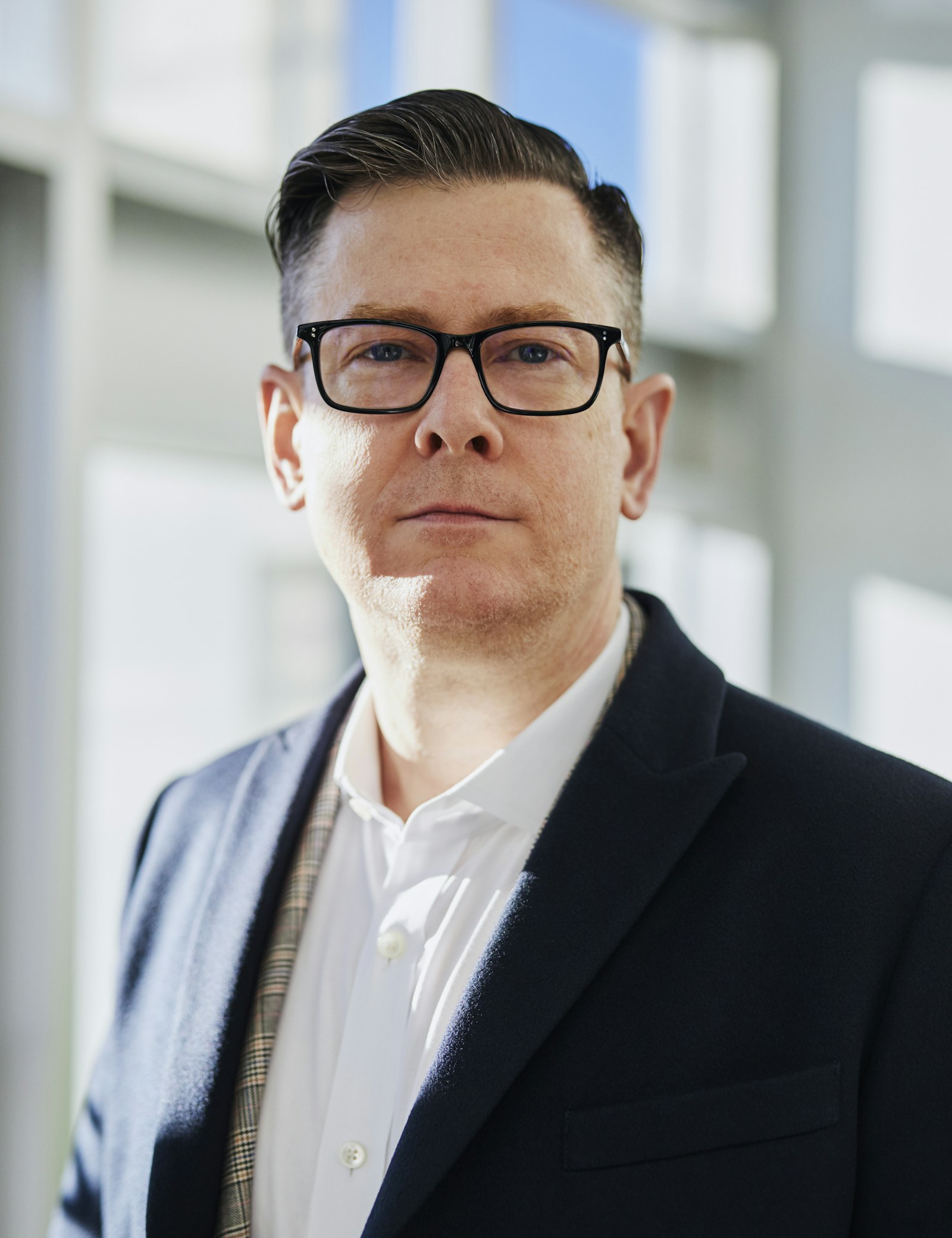 Attorney in a suit standing in the firm's office